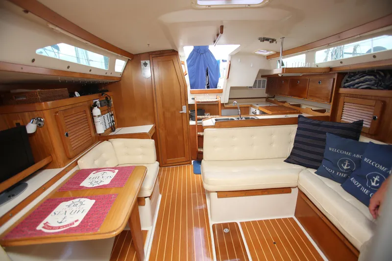 Slide: The Image of Interior of a 2002 Catalina 36 sailboat with wooden finishes and cozy seating. - 5