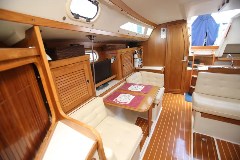 Slide: The Image of Interior of 2002 Catalina 36 sailboat with wooden finishes and cozy seating area. - 6