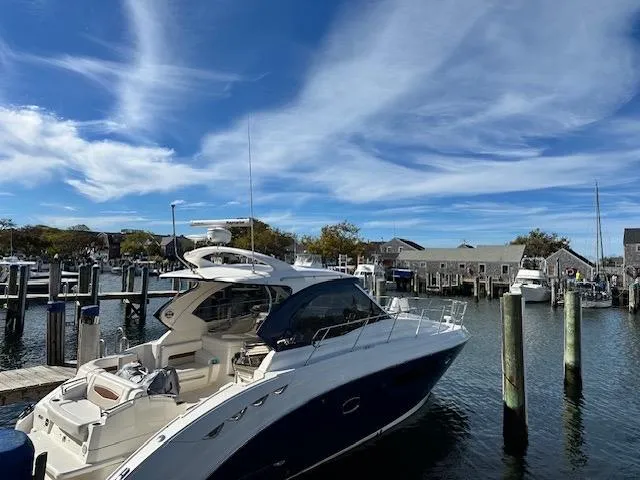 The Image of 2010 Chaparral 400 Premiere yacht docked at a marina under a clear blue sky. - 0