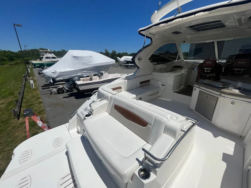Slide: The Image of 2010 Chaparral 400 Premiere yacht interior with seating and helm, docked outdoors. - 10