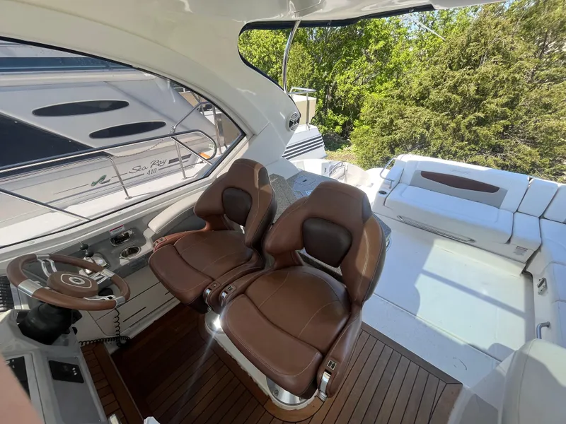 Slide: The Image of 2010 Chaparral 400 Premiere yacht cockpit with brown leather seats and wooden flooring. - 15