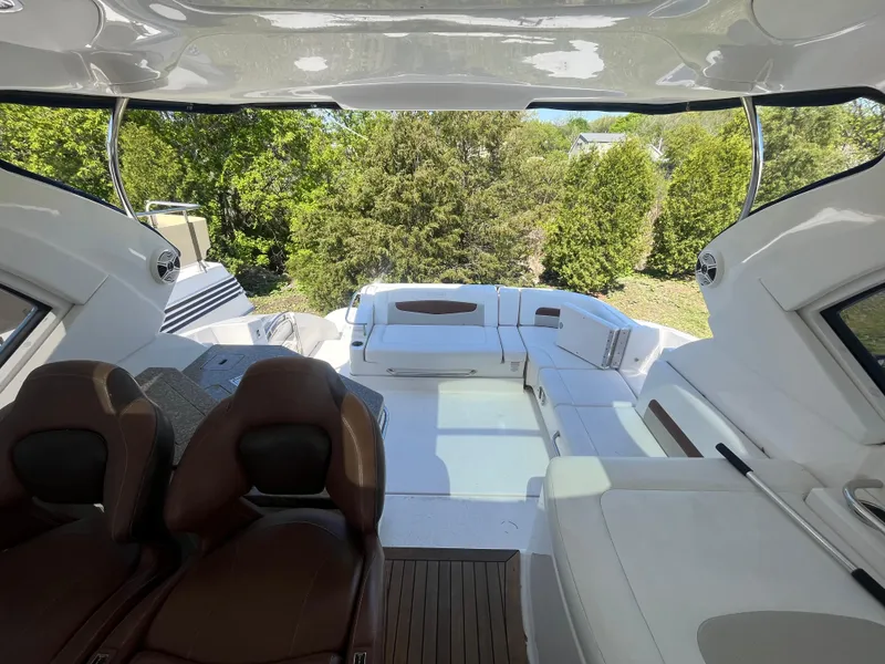 Slide: The Image of Interior view of 2010 Chaparral 400 Premiere yacht with seating and lush greenery outside. - 16