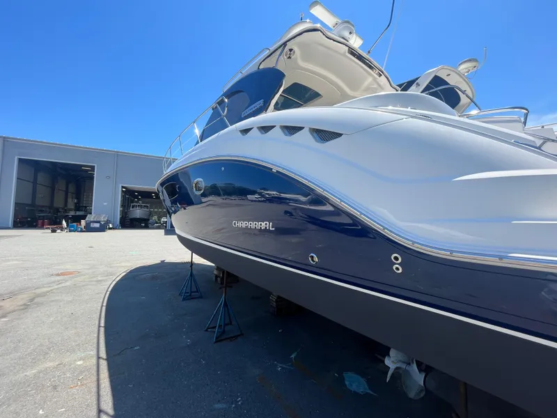 Slide: The Image of 2010 Chaparral 400 Premiere yacht on stands, outside a large warehouse, under clear blue sky. - 5