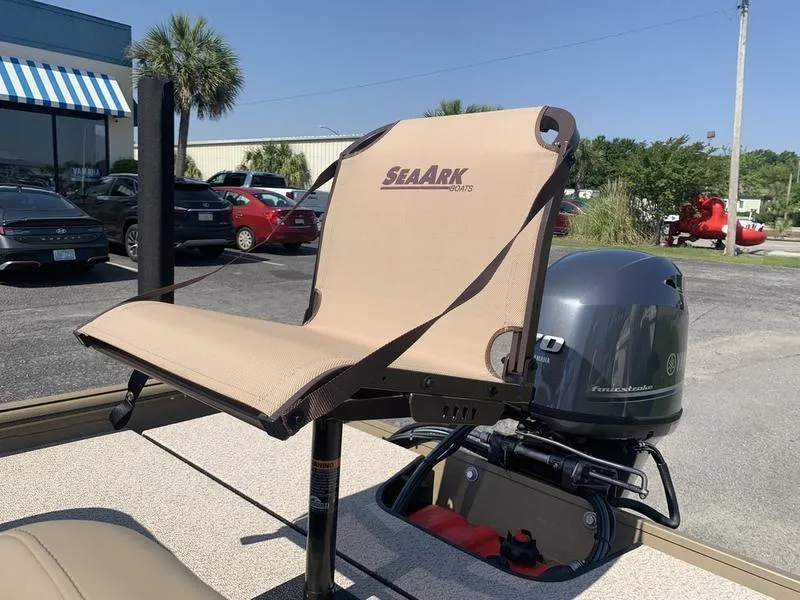Slide: The Image of 2025 SeaArk Shadow 18 Center Console boat seat and motor in a parking lot. - 11