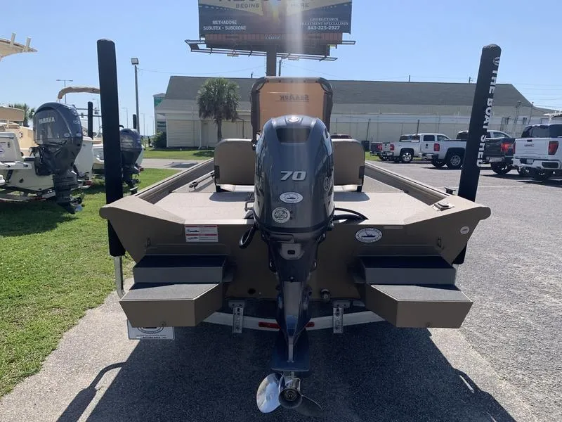 Slide: The Image of 2025 SeaArk Shadow 18 Center Console boat with 70 HP outboard motor, parked outdoors. - 3