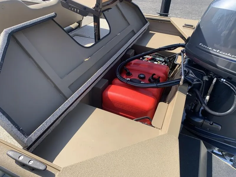 Slide: The Image of 2025 SeaArk Shadow 18 Center Console boat with open storage compartment and red fuel tank. - 9