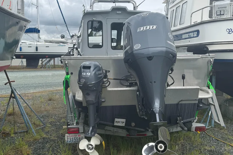 Slide: The Image of 2017 Hewescraft 240 Ocean Pro HT boat with dual outboard motors, parked on gravel. - 11