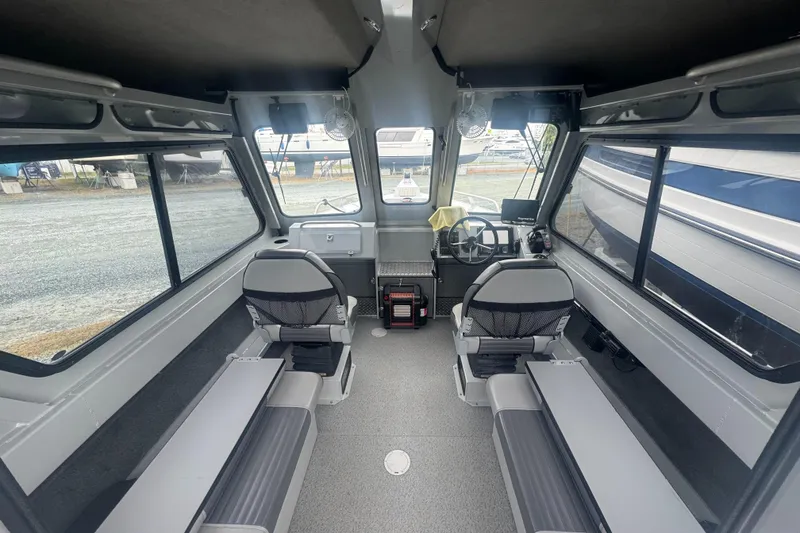 Slide: The Image of 2017 Hewescraft 240 Ocean Pro HT interior with seating and helm, showcasing spacious cabin design. - 14