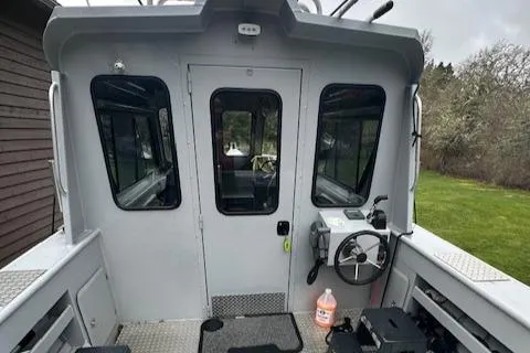 Slide: The Image of 2017 Hewescraft 240 Ocean Pro HT boat cockpit with steering wheel and cabin door. - 7