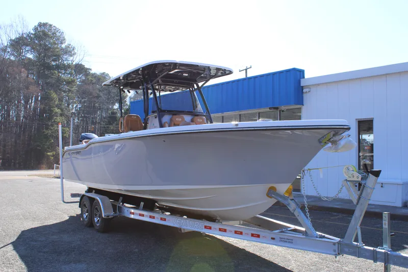 The Image of 2025 Key West 263 FS boat on trailer, parked outdoors with trees in background. - 0
