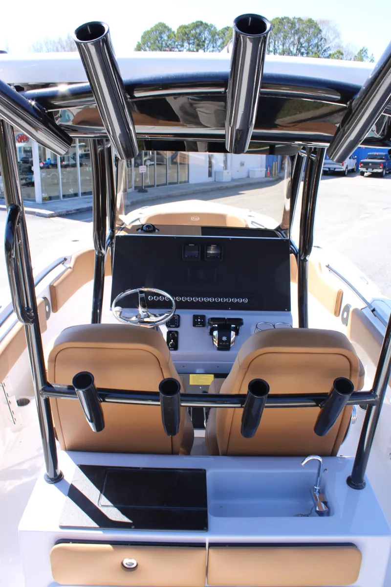 Slide: The Image of 2025 Key West 263 FS boat with tan seating and black T-top in a marina. - 13