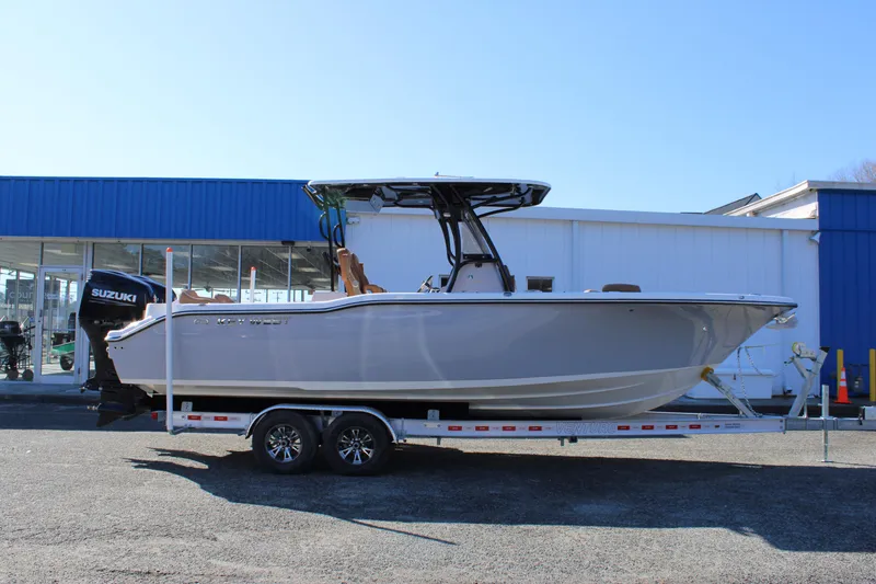 Slide: The Image of 2025 Key West 263 FS boat with dual 300 horsepower outboard engines, parked outdoors. - 3