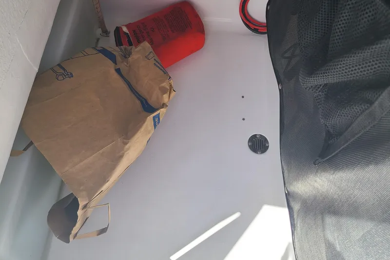 Slide: The Image of 2021 Sportsman Open 212 Center Console interior with fire extinguisher and paper bag. - 12