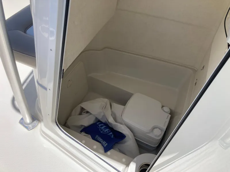 Slide: The Image of Interior of a 2012 Sailfish 2180 boat with storage compartment and portable toilet. - 14