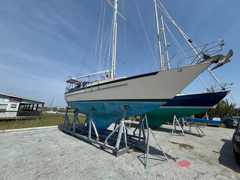 Slide: The Image of Sailboat on stands, Pacific Seacraft Crealock 37, 1995 model, in a boatyard under clear skies. - 2