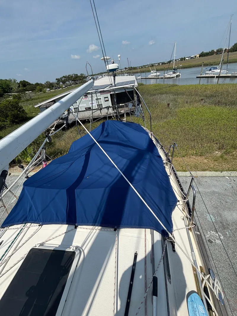 Slide: The Image of 1995 Pacific Seacraft Crealock 37 sailboat docked near a serene waterfront. - 20