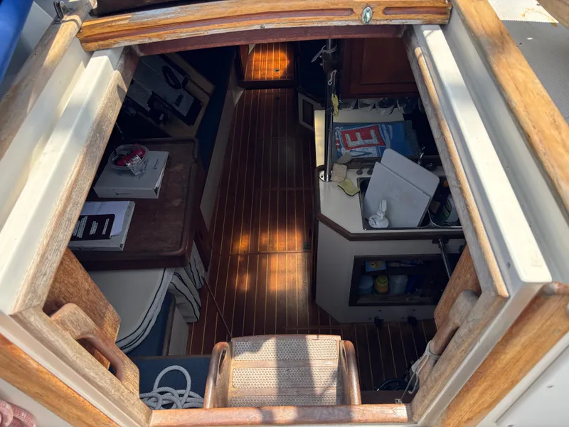 Slide: The Image of Interior view of a 1995 Pacific Seacraft Crealock 37 sailboat, showcasing wooden flooring and cabin details. - 21