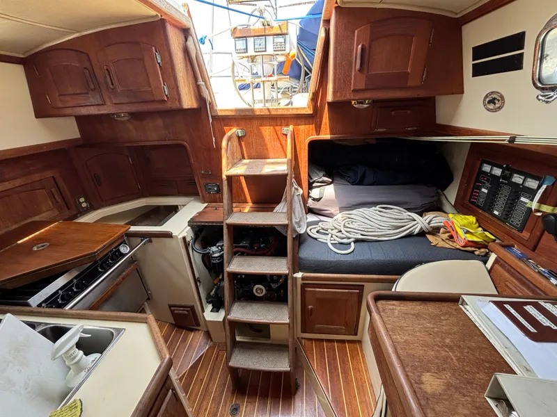 Slide: The Image of Interior of 1995 Pacific Seacraft Crealock 37 sailboat, featuring wood cabinetry and compact living space. - 22