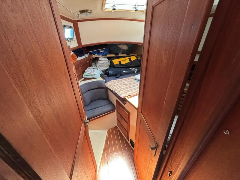 Slide: The Image of Interior of 1995 Pacific Seacraft Crealock 37 sailboat, featuring wooden cabinetry and seating area. - 31