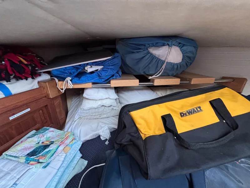 Slide: The Image of Storage area in a 1995 Pacific Seacraft Crealock 37, featuring bags and bedding. - 38