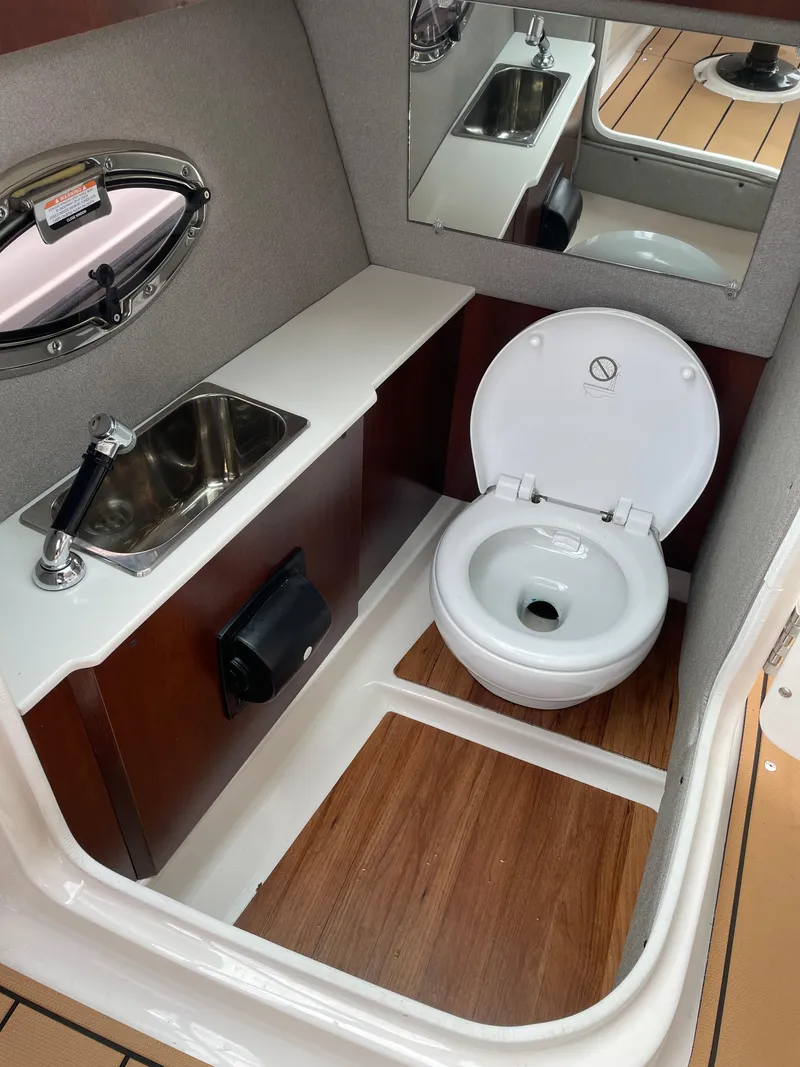 Slide: The Image of 2023 Chaparral 287 SSX boat bathroom with sink, toilet, and wood flooring. - 11