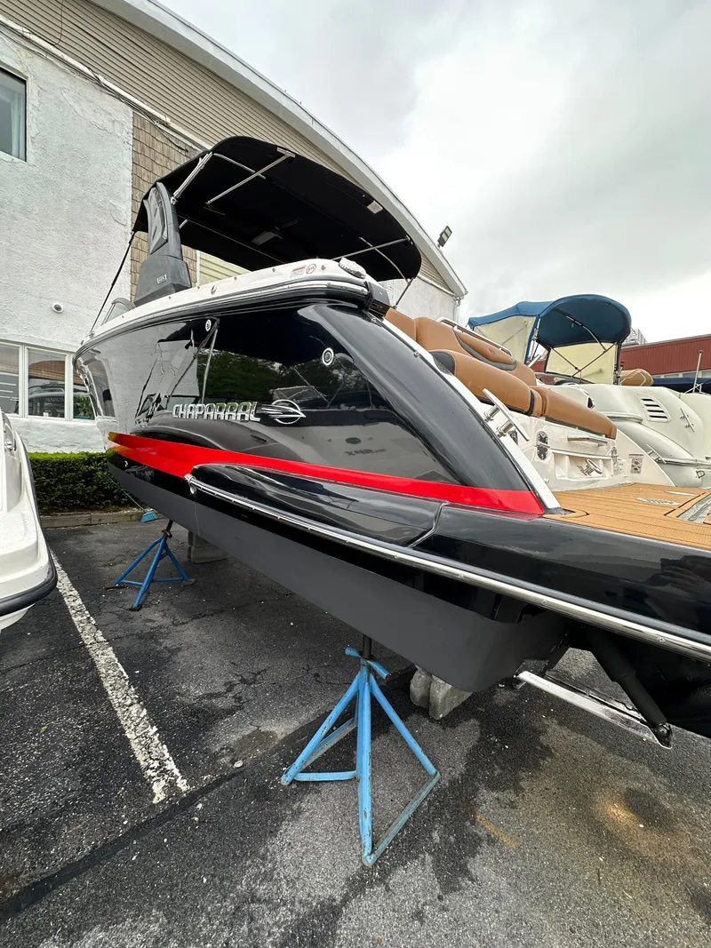 Slide: The Image of 2023 Chaparral 287 SSX boat displayed on stands, featuring sleek design and modern amenities. - 2