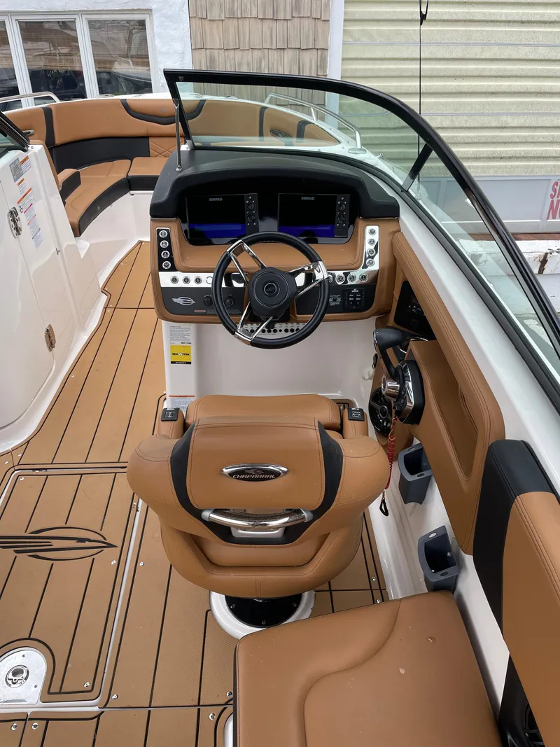 Slide: The Image of 2023 Chaparral 287 SSX boat interior with tan seating and modern dashboard. - 24