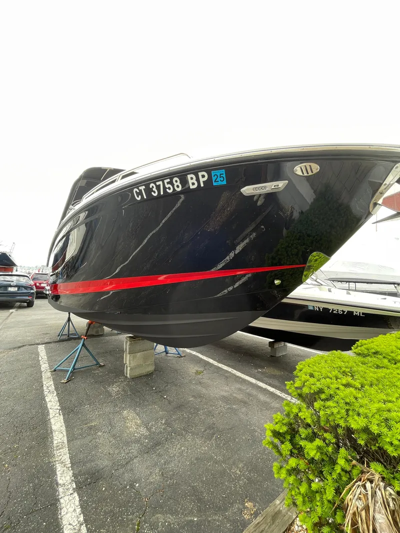 Slide: The Image of 2023 Chaparral 287 SSX boat on display, black hull with red stripe. - 28