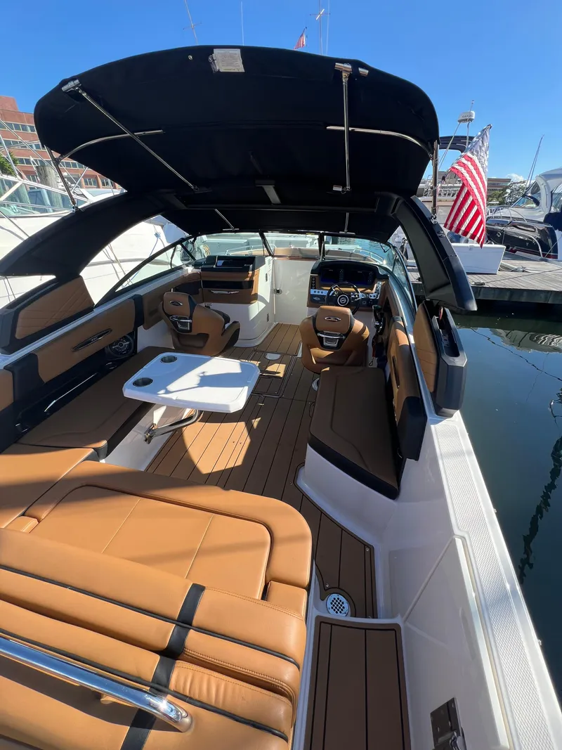 Slide: The Image of 2023 Chaparral 287 SSX boat with tan seating, docked at marina under clear blue sky. - 3
