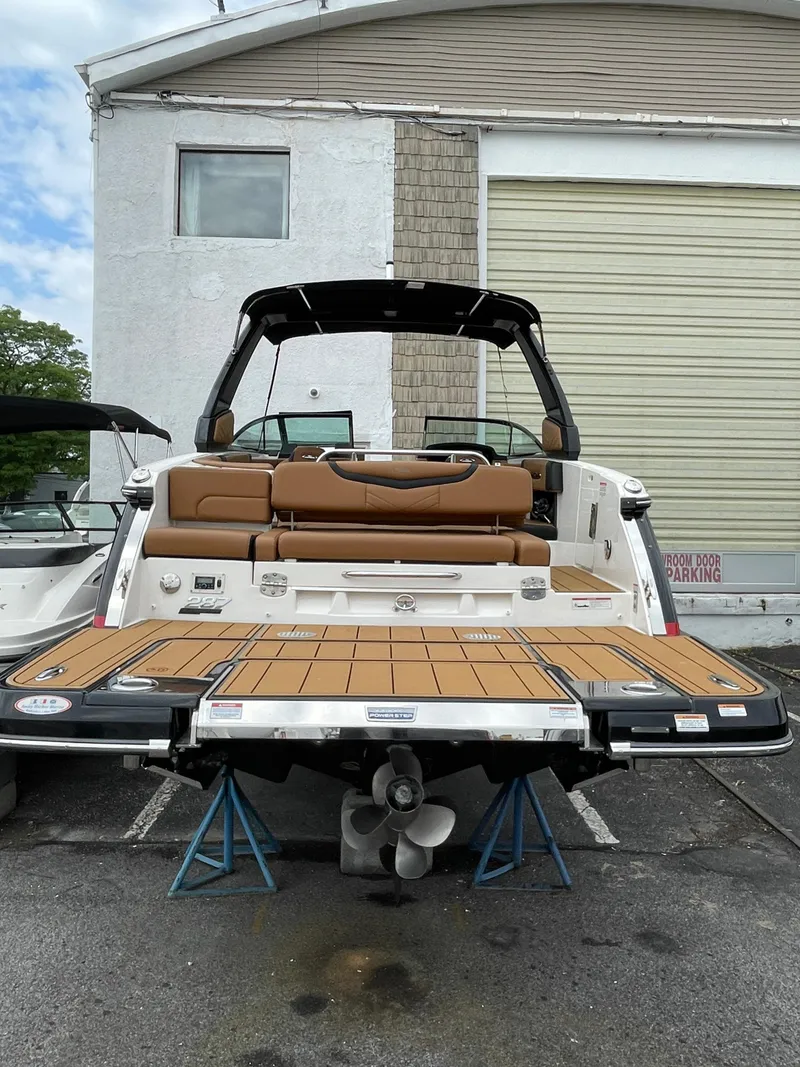 Slide: The Image of 2023 Chaparral 287 SSX boat with open swim platform, docked on stands. - 33