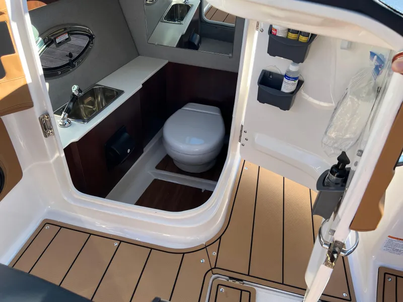 Slide: The Image of 2023 Chaparral 287 SSX boat interior with toilet, sink, and storage compartments. - 4