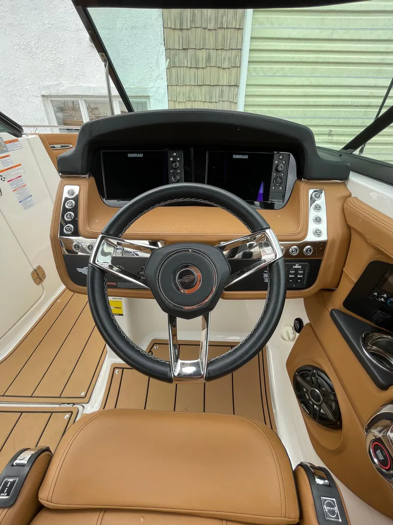 Slide: The Image of 2023 Chaparral 287 SSX boat dashboard with modern controls and leather steering wheel. - 8