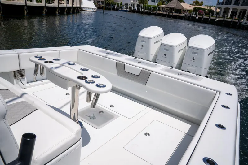 Slide: The Image of 2023 Contender 44 CB boat with triple outboard engines on a calm waterway. - 14