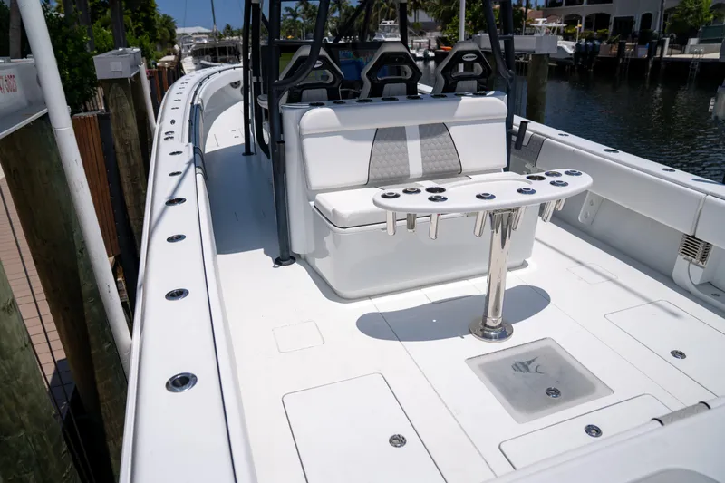 Slide: The Image of 2023 Contender 44 CB boat with seating and rod holders, docked by the water. - 15