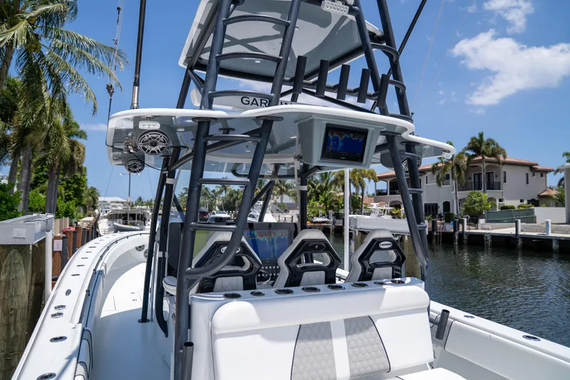 Slide: The Image of 2023 Contender 44 CB boat with advanced navigation system, docked by a canal under a clear sky. - 17