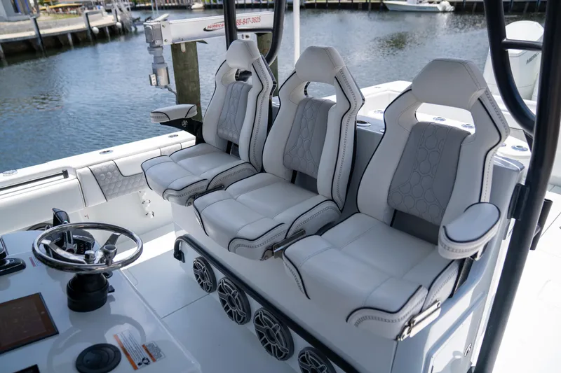 Slide: The Image of 2023 Contender 44 CB boat interior with three luxury seats and steering wheel. - 19