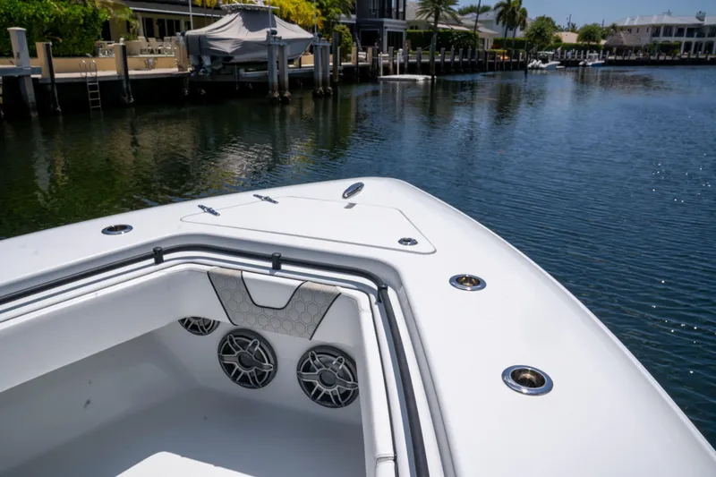Slide: The Image of 2023 Contender 44 CB boat bow with speakers, docked in a serene waterfront setting. - 34