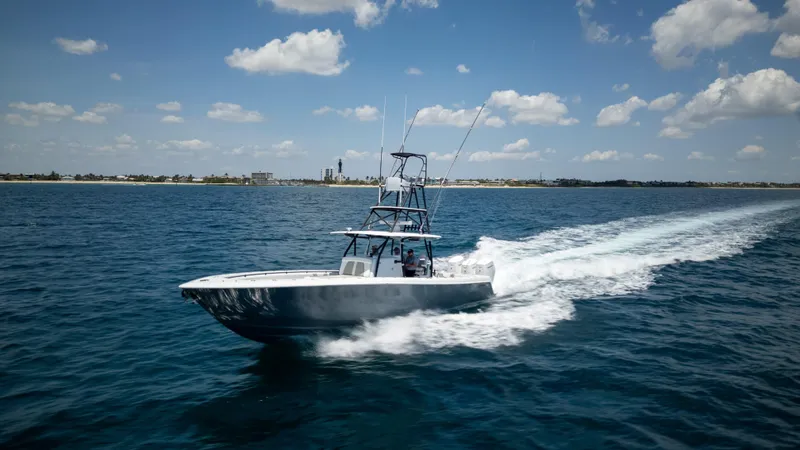 Slide: The Image of 2023 Contender 44 CB boat cruising on open water under a clear blue sky. - 42