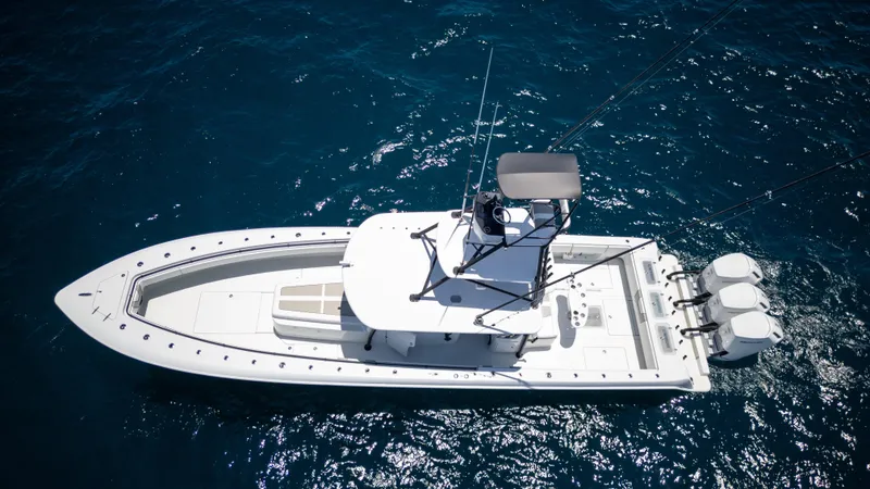 Slide: The Image of 2023 Contender 44 CB boat on open water, aerial view, featuring triple outboard engines. - 6
