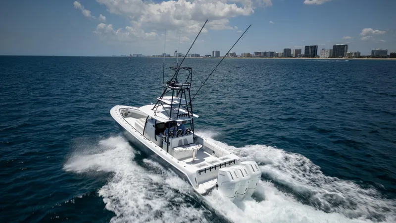 Slide: The Image of 2023 Contender 44 CB boat cruising on open ocean near city skyline. - 7