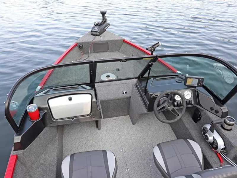 Slide: The Image of 2026 Lund 1650 Angler boat interior with steering wheel, seats, and fishing equipment. - 4