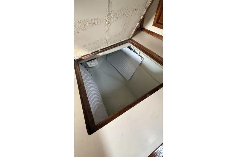 Slide: The Image of Open hatch on 1979 Ericson 30 Plus boat, revealing storage compartment. - 11