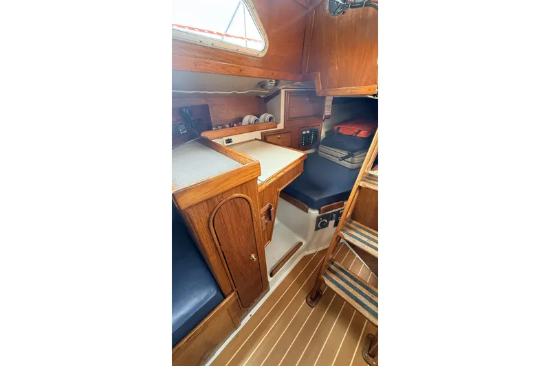 Slide: The Image of 1979 Ericson 30 Plus sailboat interior with wooden cabinetry and seating area. - 12