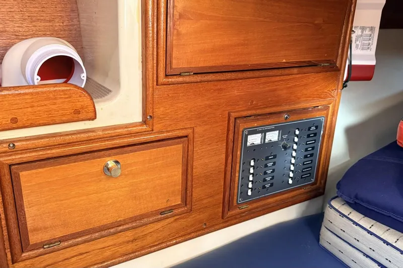 Slide: The Image of 1979 Ericson 30 Plus sailboat interior with wooden cabinetry and electrical panel. - 13