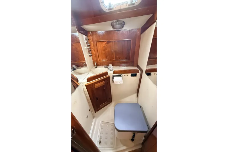 Slide: The Image of 1979 Ericson 30 Plus yacht bathroom with wooden cabinetry and compact design. - 14