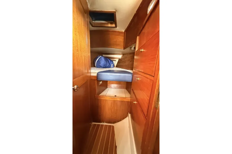 Slide: The Image of 1979 Ericson 30 Plus sailboat interior with wooden cabinetry and cozy sleeping area. - 15