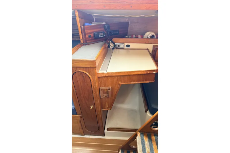 Slide: The Image of 1979 Ericson 30 Plus yacht interior with wooden cabinetry and navigation station. - 16