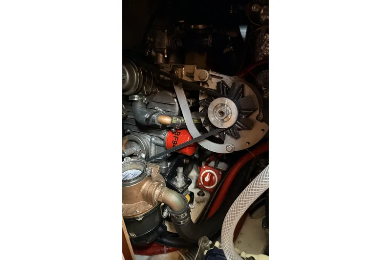 Slide: The Image of Engine components of a 1979 Ericson 30 Plus sailboat, featuring belts and hoses. - 19