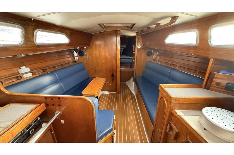 Slide: The Image of Interior of a 1979 Ericson 30 Plus sailboat with wooden finish and blue seating. - 2
