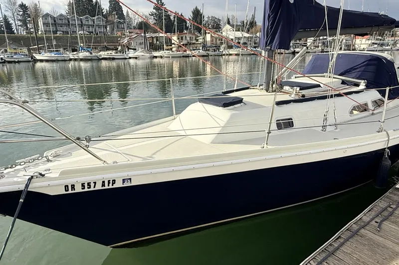 Slide: The Image of 1979 Ericson 30 Plus sailboat docked in a marina, surrounded by other boats. - 20